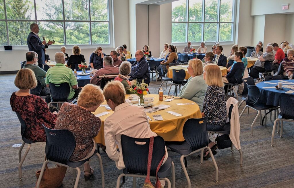 Dr. Phil Gale speaks to the room full of retirees.