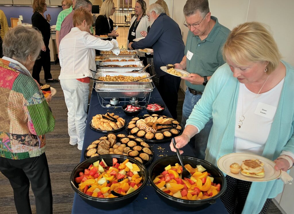 Several retires go through the food line.